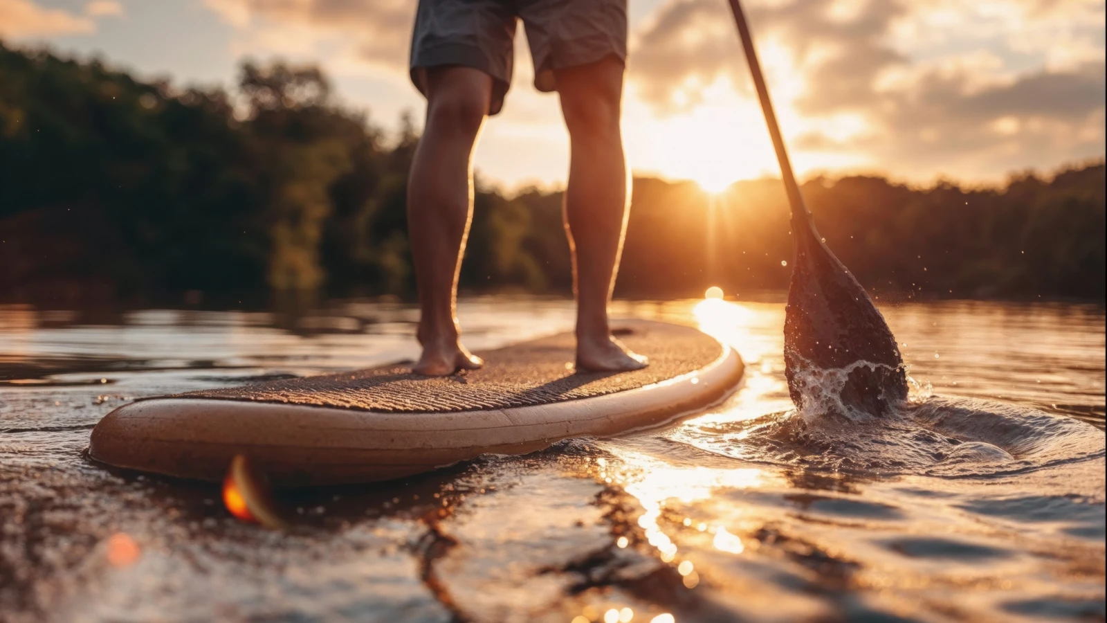 person paddle boarding at sunset