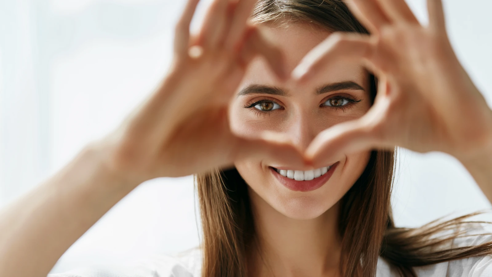 kind woman making a heart with her hands