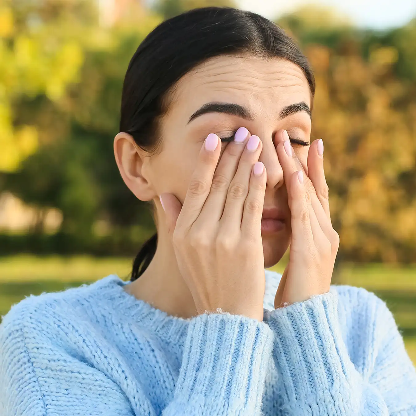 young woman rubbing eyes from allergies
