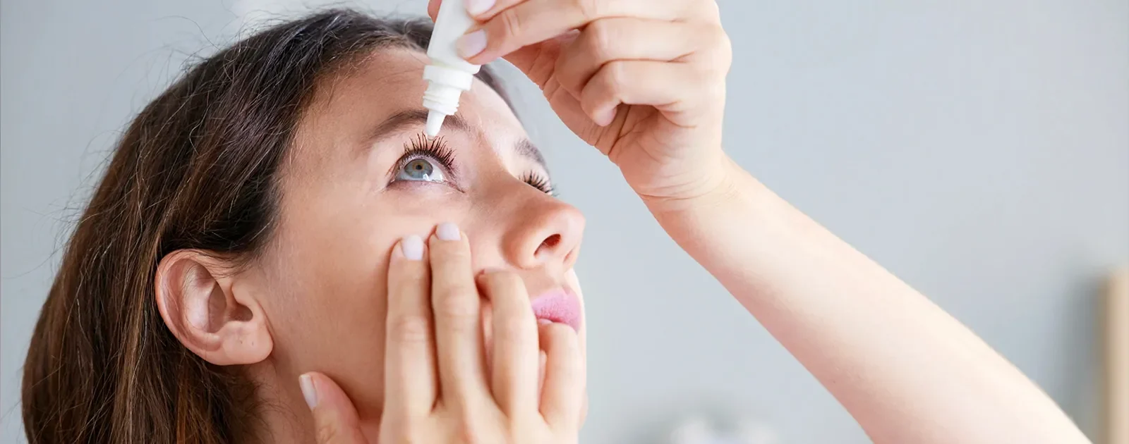 woman using eye drops