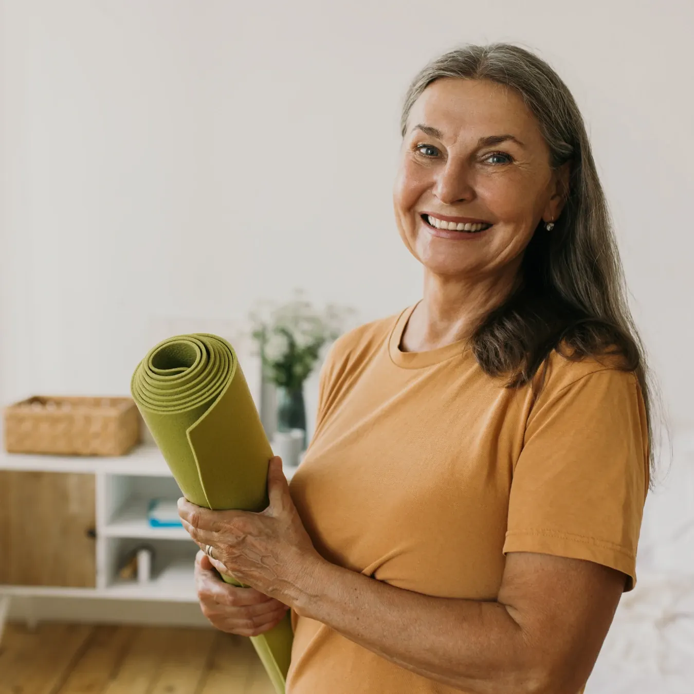 healthy mature woman holding yoga mat
